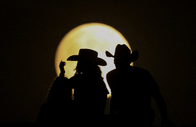 People look at the full moon on the day of the lunar eclipse at the Samalayuca Dunes on the outskirts of Ciudad Juarez, Mexico on September 17, 2024. (Photo by Jose Luis Gonzalez/Reuters)