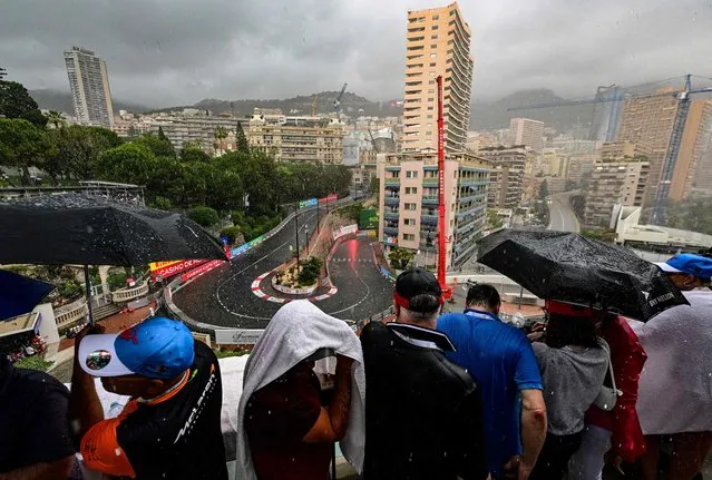 Spectators wait in the rain for the start of the Monaco Formula 1 Grand Prix at the Monaco street circuit in Monaco, on May 29, 2022. (Photo by Sebastien Bozon/AFP Photo)