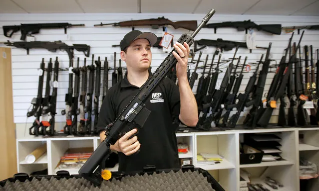 Salesman, Ryan Martinez inspects a new AR-10 at the “Ready Gunner” gun store in Provo, Utah, U.S., June 21, 2016. (Photo by George Frey/Reuters)