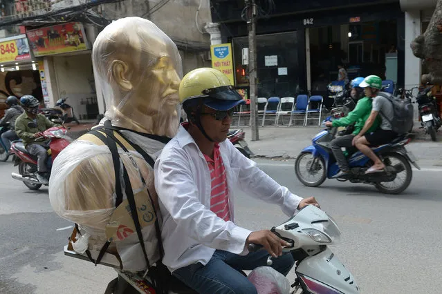 This picture taken on June 27, 2017 shows a deliveryman on a motorcycle transporting a bust of Vietnam' s late president Ho Chi Minh to a customer in downtown Hanoi. (Photo by Hoang Dinh Nam/AFP Photo)