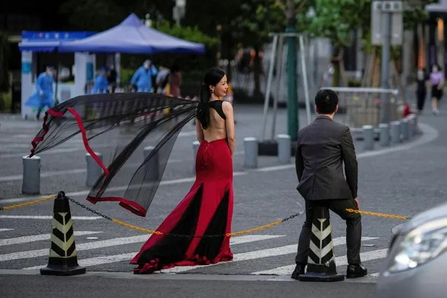 A couple prepare for their wedding photo session in front of a nucleic acid testing site, after the lockdown placed to curb the coronavirus disease (COVID-19) outbreak was lifted in Shanghai, China on June 8, 2022. (Photo by Aly Song/Reuters)