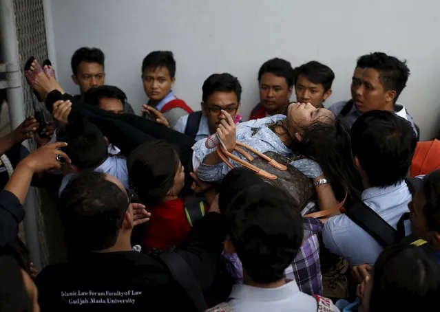 A woman, who fainted, is carried by others at the Indonesia Spectacular Job Fair 2015 at Gelora Bung Karno stadium in Jakarta August 12, 2015. (Photo by Reuters/Beawiharta)