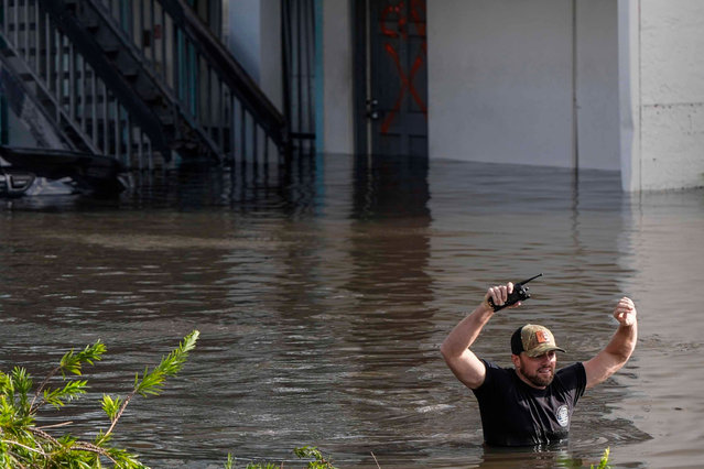 A water rescue team member walks through floodwaters at an apartment complex in the aftermath of Hurricane Milton, Thursday, October 10, 2024, in Clearwater, Fla. (Photo by Mike Stewart/AP Photo)