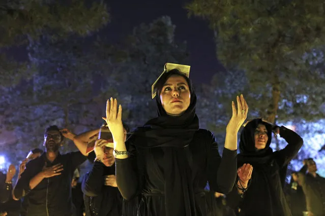 Iranian Shiite Muslims pray as they place the Quran on their heads at the graves of soldiers who were killed during 1980-88 Iran-Iraq War, at the Behesht-e-Zahra cemetery, during the holy fasting month of Ramadan, just outside Tehran, Iran, Monday, June 27, 2016. Iranian Muslims spent the night in prayer and devotion commemorating Laylat Al Qadr, or the Night of Power, which is the anniversary of the night that Muslims believe Prophet Muhammad received the first revelation of the Quran by the angel Gabriel. (Photo by Ebrahim Noroozi/AP Photo)