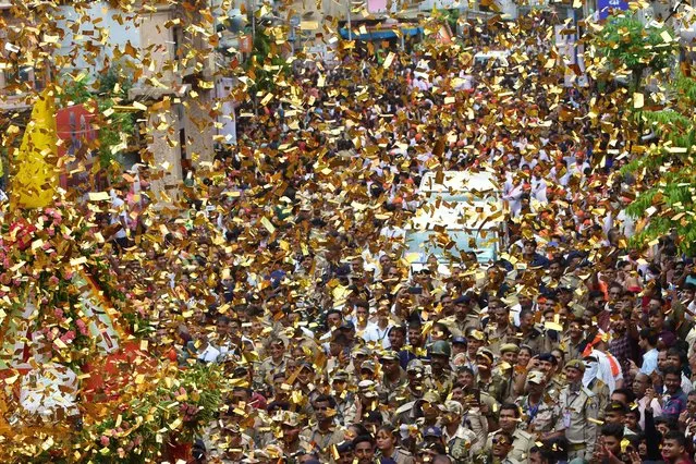 Police personnel march amid confetti during the 145th Rath Yatra of Lord Jagannath religious procession in Ahmedabad on July 1, 2022. (Photo by Sam Panthaky/AFP Photo)