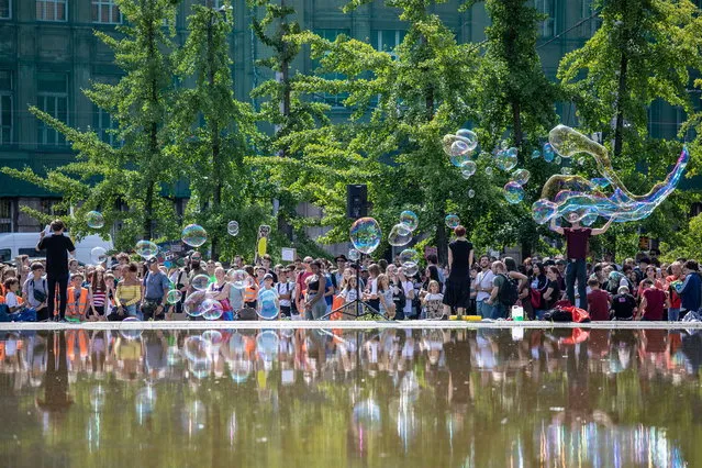 Protesters hold signs and make soap bubles during a 'Fridays for Future' demonstration near the Federal Ministry of Economy in Berlin, Germany, 09 August 2019. Students across the world are taking part in the strike movement called #FridayForFuture, which takes place every Friday. The movement was sparked by 16-year-old Greta Thunberg of Sweden, a student who started protesting for climate action and the implementation of the Paris Agreement. The “Fridays for Future” movement, which started in the summer of 2018, demands compliance with the goals of the Paris Agreement and the 1.5 degree Celsius reduction target. (Photo by Omer Messinger/EPA/EFE)