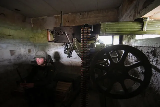 A member of the Ukrainian National Guard sits near a Maxim machine gun at a position near a front line in Kharkiv region, as Russia's attack on Ukraine continues, Ukraine on August 3, 2022. (Photo by Vyacheslav Madiyevskyy/Reuters)