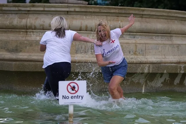 England supporters celebrate in a fountain in Trafalgar Square after watching their team win the final of the Women's Euro 2022 soccer match between England and Germany being played at Wembley stadium in London, Sunday, July 31, 2022. (Photo by Frank Augstein/AP Photo)
