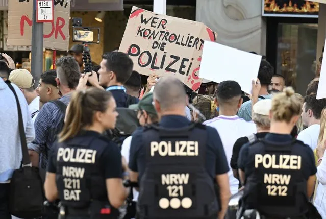 Two days after the fatal police shooting of a 16-year-old, several hundred demonstrators protest against the death of the boy in front of the North Police Station in Dortmund, Germany, Wednesday, August 10, 2022. A German top security official vowed Thursday to fully investigate the fatal shooting of a 16-year-old Senegalese refugee boy by police earlier this week that has sparked a debate over inappropriate police violence in the country. Slogan reads: “Who Controls The Police?”. (Photo by Roberto Pfeil/dpa via AP Photo)