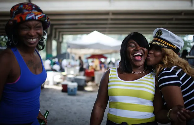 Survivors Tree Lyons (R) and Nell Lampkin (2nd R) laugh while posing at a celebration at the end of a second line parade which departed from the Lower Ninth Ward marking the 10th anniversary of Hurricane Katrina on August 29, 2015 in New Orleans, Louisiana. (Photo by Mario Tama/Getty Images)