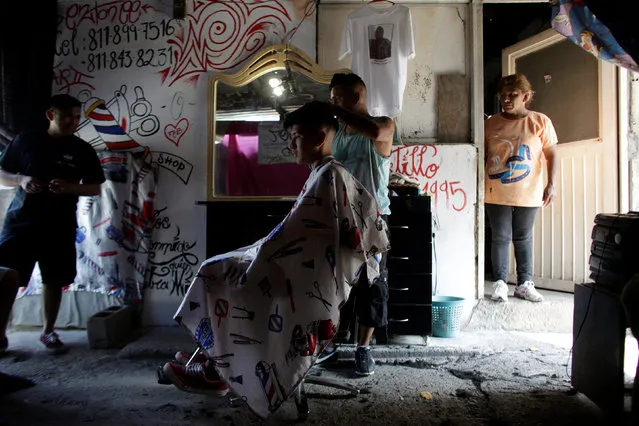 A barber gives a haircut to a young man, both attending the meetings of Raza Nueva in Christ, a project of the archdiocese of Monterrey, at a barbershop in the municipality of Juarez, on the outskirts of Monterrey, Mexico, June 25, 2016. (Photo by Daniel Becerril/Reuters)