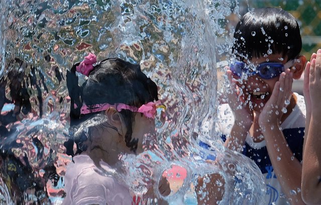 Children play at the Taipei Water Park to beat the heat in Taiwan's capital Taipei on July 28, 2016. According the Taiwan's Central Weather Bureau the highest temperature reached 38.5 C (101 F), recorded as the second-hottest day for July as the whole island swelters. (Photo by Sam Yeh/AFP Photo)