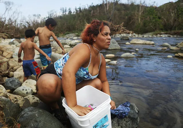 Maria Chiclano, who has no running water or power in her home, washes clothes with her sons in the Espiritu Santo river during heavy rains more than two weeks after Hurricane Maria hit the island, on October 8, 2017 in Palmer, Puerto Rico. Only 11.7 percent of Puerto Rico's electricity has been restored and some residents are going to the river to wash clothes, gather water, cool off, or bathe. The area borders the El Yunque National Forest, the United States' only tropical rainforest, which was heavily damaged by the hurricane. Puerto Rico experienced widespread damage including most of the electrical, gas and water grid as well as agriculture after Hurricane Maria, a category 4 hurricane, swept through.  (Photo by Mario Tama/Getty Images)