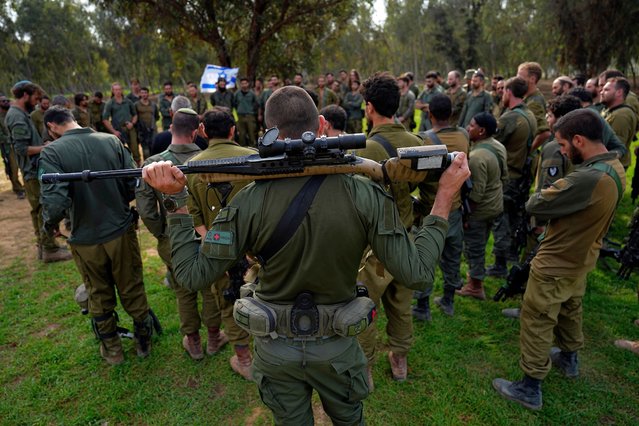 Israeli soldiers are briefed after coming back from the Gaza Strip at a staging area in southern Israel, Sunday, December 17, 2023. (Photo by Ariel Schalit/AP Photo)