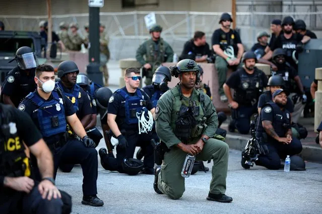 Officers kneel with protesters during a protest against the death in Minneapolis in police custody of African-American man George Floyd, in Downtown Atlanta, Georgia, U.S. June 1, 2020. (Photo by Dustin Chambers/Reuters)
