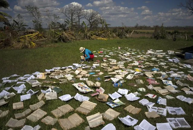 A teacher dries out books at a school that was heavily damaged by Hurricane Ian in La Coloma, in the province of Pinar del Rio, Cuba, Wednesday, October 5, 2022  (Photo by Ramon Espinosa/AP Photo)