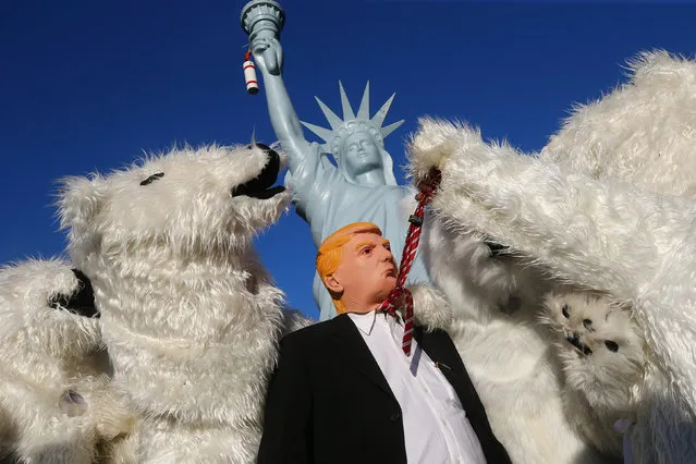 A protester wearing a mask of U.S. President Donald Trump stands along with other protesters dressed as polar bears during a demonstration under the banner “Protect the climate – stop coal” two days before the start of the COP 23 UN Climate Change Conference hosted by Fiji but held in Bonn, Germany November 4, 2017. (Photo by Wolfgang Rattay/Reuters)