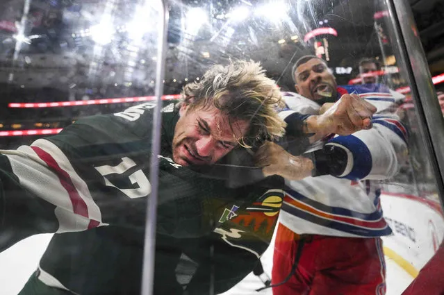New York Rangers right wing Ryan Reaves punches Minnesota Wild left wing Marcus Foligno (17) during a third-period fight in an NHL hockey game Thursday, October 13, 2022, in St. Paul, Minn. (Photo by Aaroan Lavinsky/Star Tribune via AP Photo)