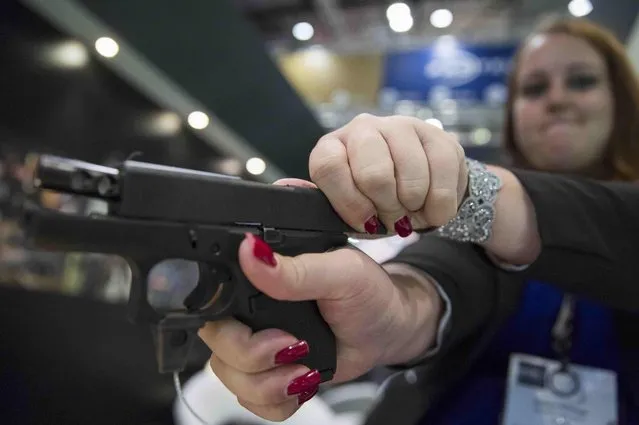 A salesperson displays a Glock 25 handgun at the Defence and Security Equipment International trade show in London, Britain September 16, 2015. (Photo by Neil Hall/Reuters)