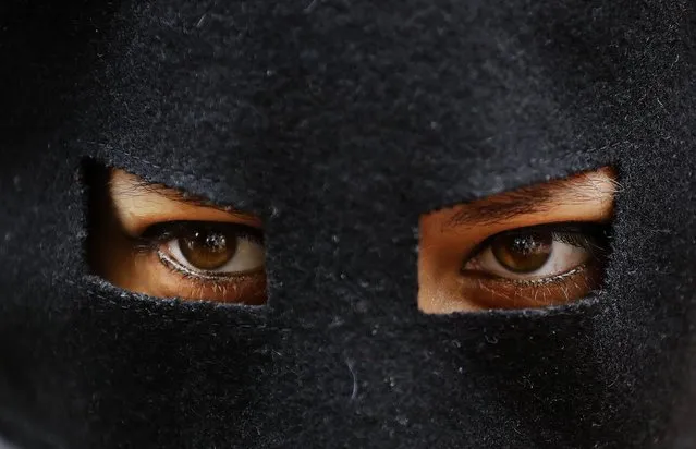 An activist protests wears a mask outside the French embassy during, the “wear what you want beach party” in London, Thursday, August 25, 2016. The protest is against the French authorities clampdown on Muslim women wearing burkinis on the beach. (Photo by Frank Augstein/AP Photo)