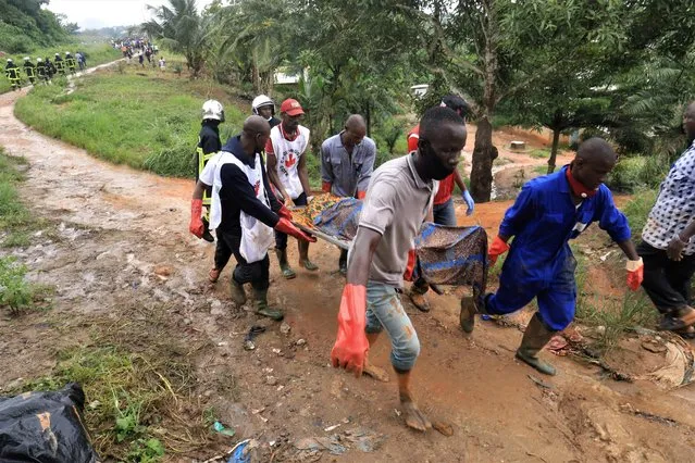 Members of a rescue team carry a body of landslide victim after unusually heavy rains, that killed at least 13 people overnight in Anyama near Abidjan, Ivory Coast on June 18, 2020. (Photo by Thierry Gouegnon/Reuters)