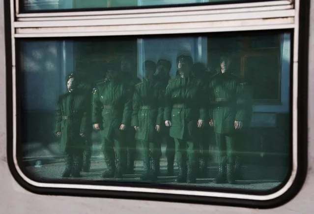 Conscripts are reflected in a window of a train carriage at a local railway station during their departure for the garrisons, in Sevastopol, Crimea on November 9, 2022. (Photo by Alexey Pavlishak/Reuters)