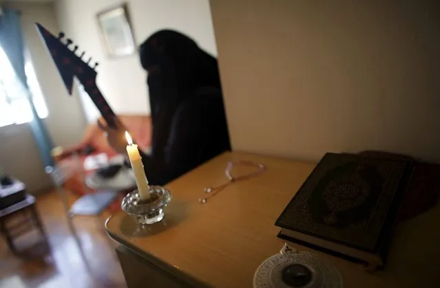 Gisele Marie, a Muslim woman and professional heavy metal musician, plays her Gibson Flying V electric guitar next to a Koran at her house in Sao Paulo August 11, 2015. (Photo by Nacho Doce/Reuters)