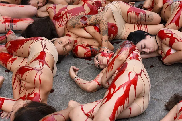 Animal rights activists covered in red paint, resembling blood pictured during a protest against fur trade on August 30, 2016 in Madrid, Spain. (Photo by Jorge Sanz/Pacific Press/Barcroft Images)