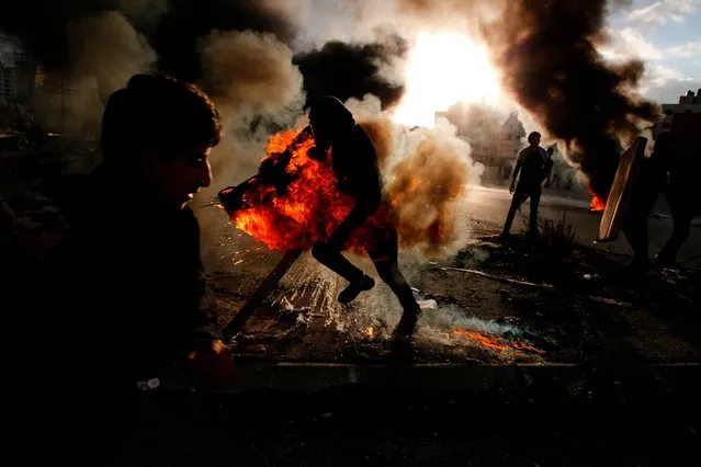 A Palestinian protester runs after catching fire during clashes with Israeli troops at a protest against US President Donald Trump' s decision to recognize Jerusalem as the capital of Israel, near the Jewish settlement of Beit El, near the West Bank city of Ramallah on December 7, 2017. (Photo by Abbas Momani/AFP Photo)