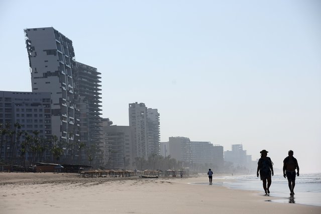 People walk in the beach as Acapulco recovers four months after hurricane Otis on February 28, 2024, in Acapulco, Mexico. Hurricane Otis made landfall, slamming the coastal Pacific resort city as a category 5 storm, claiming at least 48 lives. (Photo by Matthew Stockman/Getty Images)