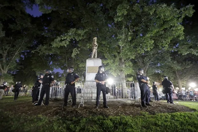 Police surround a Confederate monument during a protest to remove the statue at the University of North Carolina in Chapel Hill, N.C., on August 22, 2017. (Photo by Gerry Broome/AP Photo)
