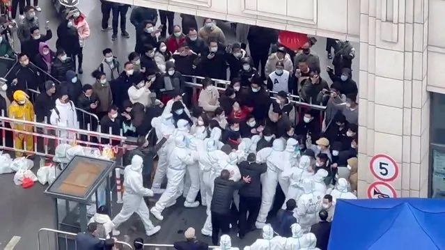 Shanghai residents confront coronavirus disease (COVID-19) staff dressed in protective clothing in Shanghai, China, in this still image obtained from a social media video released November 30, 2022. (Video obtained by Reuters)