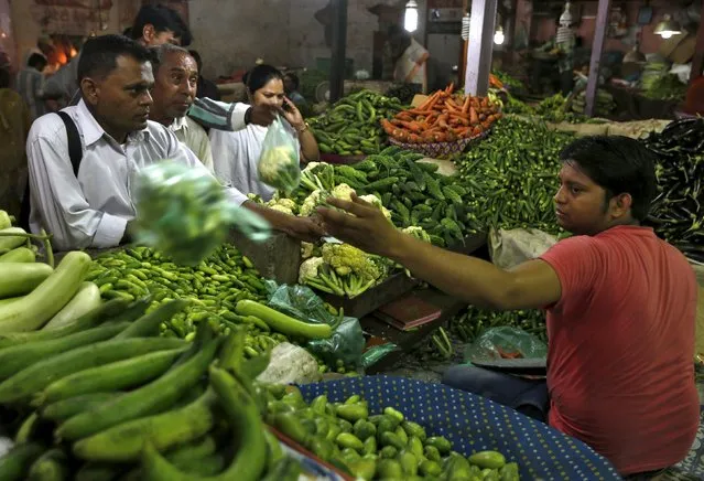 Customers buy vegetables at a market in Ahmedabad, India, September 29, 2015. Indian households expect consumer inflation to remain in double digits over the next three months and the next year, according to a quarterly survey by the central bank on Tuesday, even as recent data showed retail prices have remained muted. (Photo by Amit Dave/Reuters)