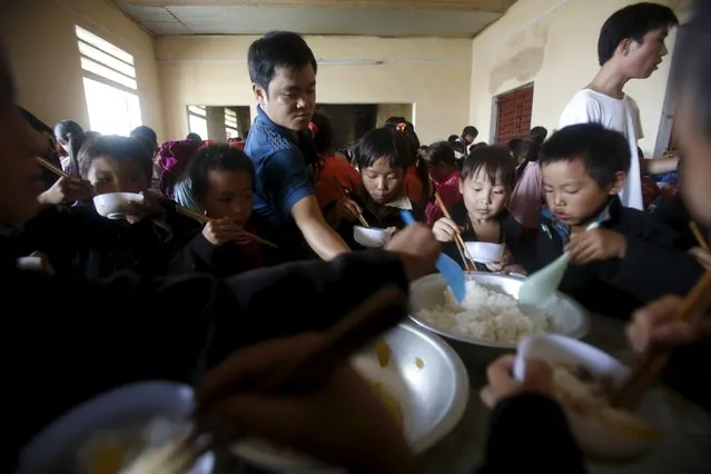 A teacher serves food to pupils of the Hmong ethnic tribe during their lunch at Van Chai school in Dong Van district of Vietnam's northern province of Ha Giang, located on the border with China, September 21, 2015. (Photo by Reuters/Kham)