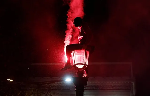 Morocco fan celebrates with a flare by the Arc de Triomphe in Paris after the match as Morocco progress to the semi finals at the FIFA World Cup on December 10, 2022. (Photo by Benoit Tessier/Reuters)