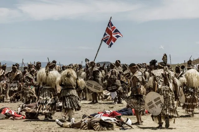 Amabutho Zulu regiments hold a British flag captured during the reenactment of the Battle of Isandlwana, in Isandlwana on January 21, 2023. The reenactment is performed annually by the Amabutho and the Dundee Diehards, a reenactment volunteers team from Dundeed. The battle, fought on January 22, 1879 was the first major encounter in the Anglo-Zulu War between the British Empire and the Zulu Kingdom. (Photo by Marco Longari/AFP Photo)