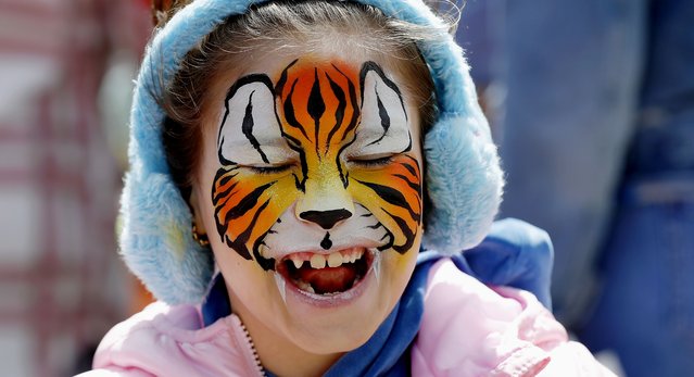 Daria, 8, a Romanian girl suffering from autism, accompanied by her mother Mihaela (not pictured), reacts after having her face painted by a volunteer entertainer during the “Blue Festival”, an event dedicated to the World Autism Awareness Day, in Obor Park, Bucharest, Romania, 02 April 2024. Dozens of children suffering from autism, accompanied by their relatives and friends and helped by volunteers, have participated in various games, painting and face painting workshops, skills and other activities organized by the NGOs Help Autism, Autism Romania, National Association for Children and Adults with Autism from Romania, Romanian Association of Therapies in Autism and ADHD under the slogan 'Not invisible!', to raise awareness among communities regarding autistic people in Romania. According to the World Health Organization (WHO), it is estimated that about 1 in 100 children is diagnosed with autism worldwide. World Autism Awareness Day, established by the United Nations General Assembly in 2007, is observed annually on 02 April. (Photo by Robert Ghement/EPA/EFE)