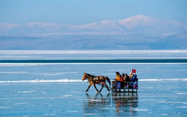 People enjoy horse-drawn sleigh on the partially frozen Lake Cildir during winter season in Kars, Turkiye on January 24, 2023. (Photo by Ismail Kaplan/Anadolu Agency via Getty Images)