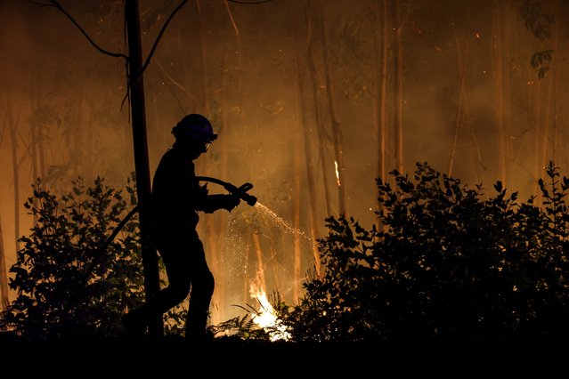 A firefighter works on a wildfire in Arouca, northern Portugal on July 30, 2025. Almost 2,700 firefighters battled Tuesday to contain forest blazes across Portugal that have led to almost the whole country being put on high alert for fires. (Photo by Carlos Costa/AFP Photo)