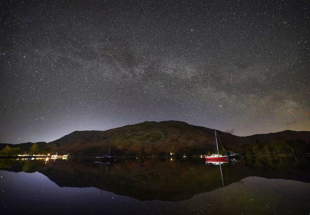 The Milky Way shines during its peak at 2.30am above boats moored on Ullswater in The Lake District, Cumbria on Wednesday, April 27, 2022. (Photo by Owen Humphreys/PA Images via Getty Images)