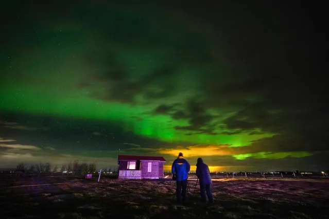 People watch the Northern Lights on a farm in Arabaer near Selfoss in Iceland on Thursday, November 24, 2022. (Photo by Owen Humphreys/PA Images via Getty Images)