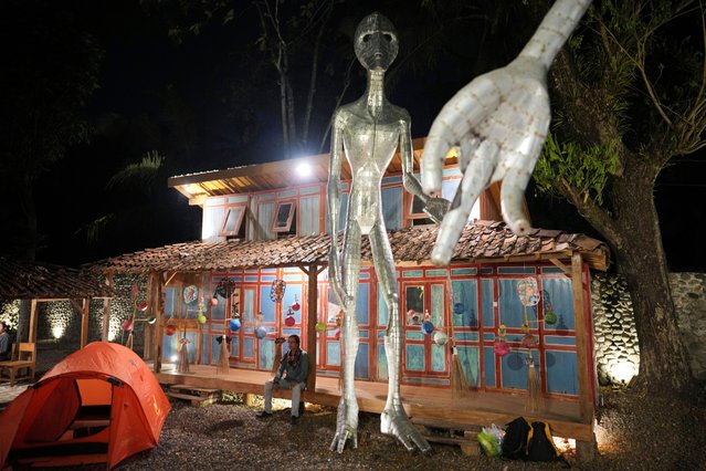 Local artist Hangno Hartono sits near an alien figure during the Indonesia UFO Festival, in Yogyakarta, Indonesia, Thursday, July 24, 2025. (Photo by Dita Alangkara/AP Photo)