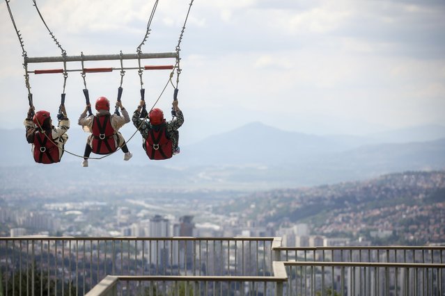 Tourists enjoy a giant swing overlooking the city on Trebevic mountain near Sarajevo, Bosnia, Tuesday, August 5, 2025. (Photo by Armin Durgut/AP Photo)