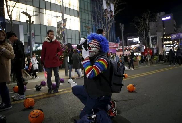 A man in costume takes photographs during Halloween celebrations in the downtown of Seoul, South Korea, October 31, 2015. (Photo by Kim Hong-Ji/Reuters)
