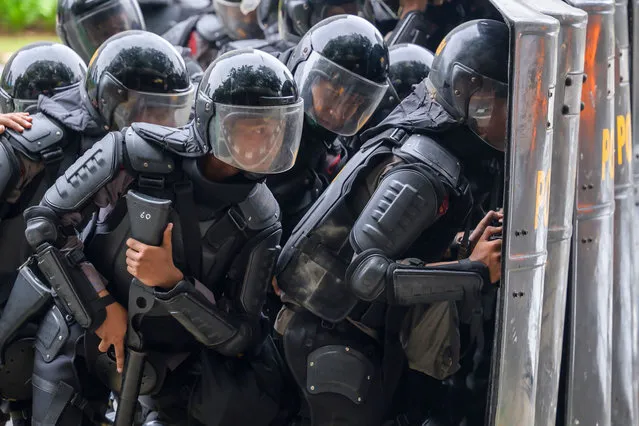 Police prepare to shoot tear gas during clashes with activists on the last day of a three-day nationwide strike against a controversial new law which critics fear will favour investors at the expense of labour rights and the environment, in Jakarta on October 8, 2020. (Photo by Bay Ismoyo/AFP Photo)