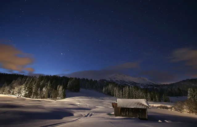 A snow covered house appears underneath the starry sky right before sunrise near Unterjoch, Germany, 29 December 2017. (Photo by Karl- Josef Hildenbrand/AFP Photo/DPA)
