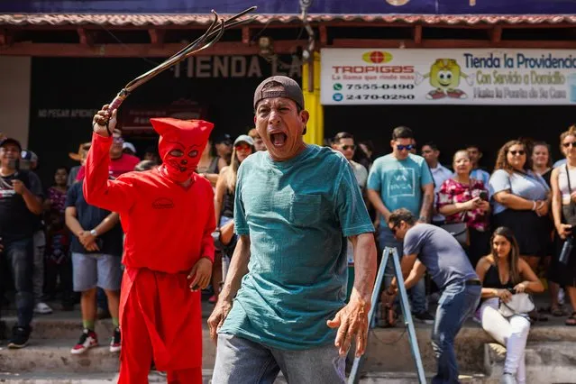 A devotee gestures after being flogged by a reveler dressed as a devil during a mass celebration of the “Talciguines” of Texistepeque, El Salvador on Easter Monday, April 3, 2023. In the Nahuatl, Talciguin means “deviled men”, a traditional procession performed during Easter monday to represent the fight against the devil of the Christian prophet Jesus Christ. (Photo by Camilo Freedman/SOPA Images/Rex Features/Shutterstock)