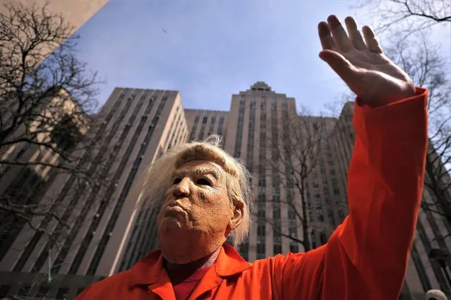 A person dressed in a costume depicting former U.S. President Donald Trump waves outside Manhattan Criminal Courthouse, on the day of Trump's court appearance after his indictment by a Manhattan grand jury following a probe into hush money paid to p*rn star Stormy Daniels, in New York City, U.S., April 4, 2023. (Photo by Carlos Barria/Reuters)