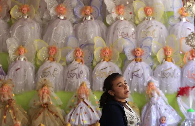 A girl is seen where traditional doll toys are displayed for sale to celebrate the birthday of prophet Muhammad, also known as “mawlid al nabi”, which will fall next week, in a makeshift tent in Cairo, December 30, 2014. (Photo by Mohamed Abd El Ghany/Reuters)