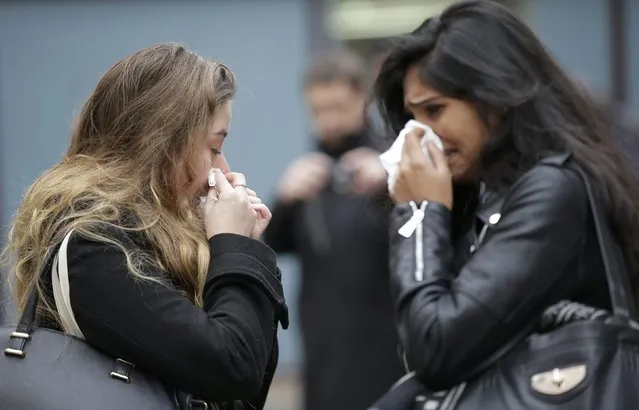 Two women cry as they pay tribute to victims outside Le Carillon restaurant, one of the attack sites in Paris, November 16, 2015. (Photo by Jacky Naegelen/Reuters)